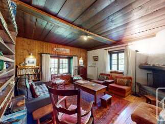 Step into this charming living room, featuring rustic wooden walls and ceiling, creating a warm and inviting atmosphere.