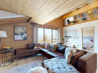 Experience luxurious mountain living in this stunning chalet featuring a spacious sectional sofa perfect for cozy evenings.