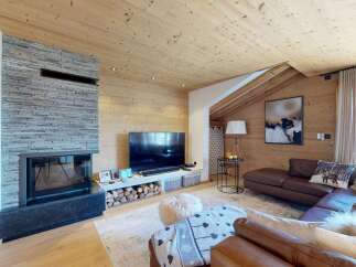 Experience luxurious mountain living in this stunning living room, featuring a modern stone fireplace and a sleek entertainment center.