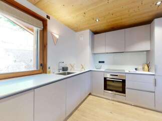 Discover this modern kitchen featuring sleek, light gray cabinetry and a clean white countertop.