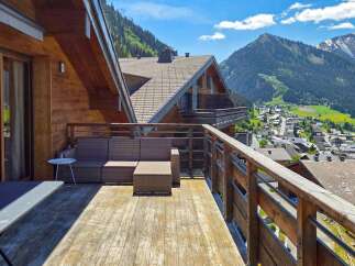 Experience breathtaking mountain views from this stunning chalet balcony, perfect for enjoying your morning coffee or evening aperitif.