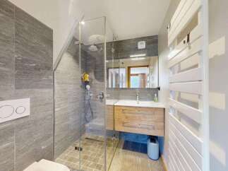 Experience modern luxury in this stunning bathroom featuring a sleek glass-enclosed shower with elegant grey tiling.