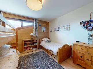 This charming bedroom features a cozy bunk bed and a single bed, perfect for family or guests.