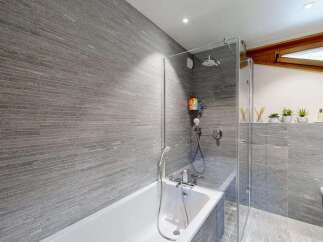 Experience modern luxury in this stunning bathroom featuring sleek, horizontal grey stone tiles that create a sophisticated and spa-like atmosphere.