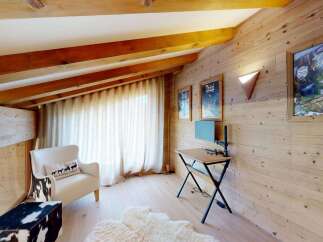 Experience rustic charm in this cozy mountain retreat, featuring exposed wooden beams and warm pine walls.