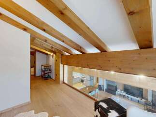 Experience modern alpine living in this stunning loft-style residence, featuring exposed wooden beams and a sleek, open-plan design.