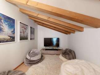 Cozy attic living space featuring exposed wooden beams and a sloped ceiling.