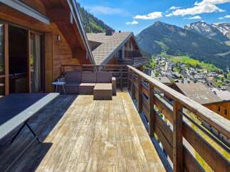 Experience breathtaking mountain views from this stunning chalet balcony, perfect for enjoying your morning coffee or evening wine.