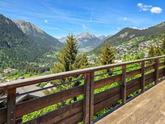 Experience breathtaking mountain views from this stunning property's expansive wooden deck and balcony.