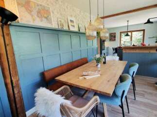 This dining area features a rustic wooden table paired with a comfortable bench and stylish chairs, perfect for family meals.