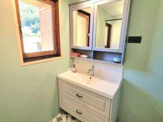 This charming bathroom features a stylish vanity with ample storage and a modern sink, complemented by a large mirrored medicine cabinet.
