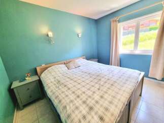 Experience comfort and style in this inviting bedroom, featuring a spacious bed with a classic plaid comforter.