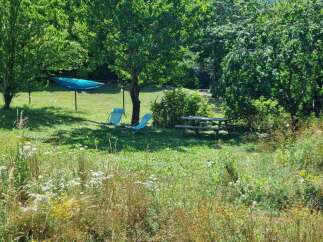 Enjoy the outdoors with this charming property featuring a relaxing hammock and two comfortable lounge chairs perfect for soaking up the sun.