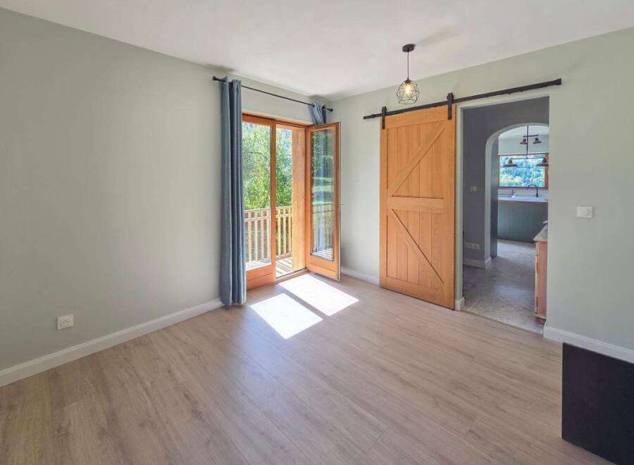 Step into this inviting room featuring a rustic wooden barn door that adds a touch of charm and character.