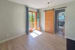 Step into this inviting room featuring a rustic wooden barn door that adds a touch of charm and character.