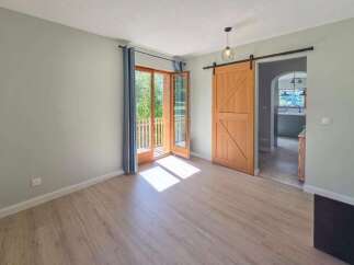 Step into this inviting room featuring a rustic wooden barn door that adds a touch of charm and character.