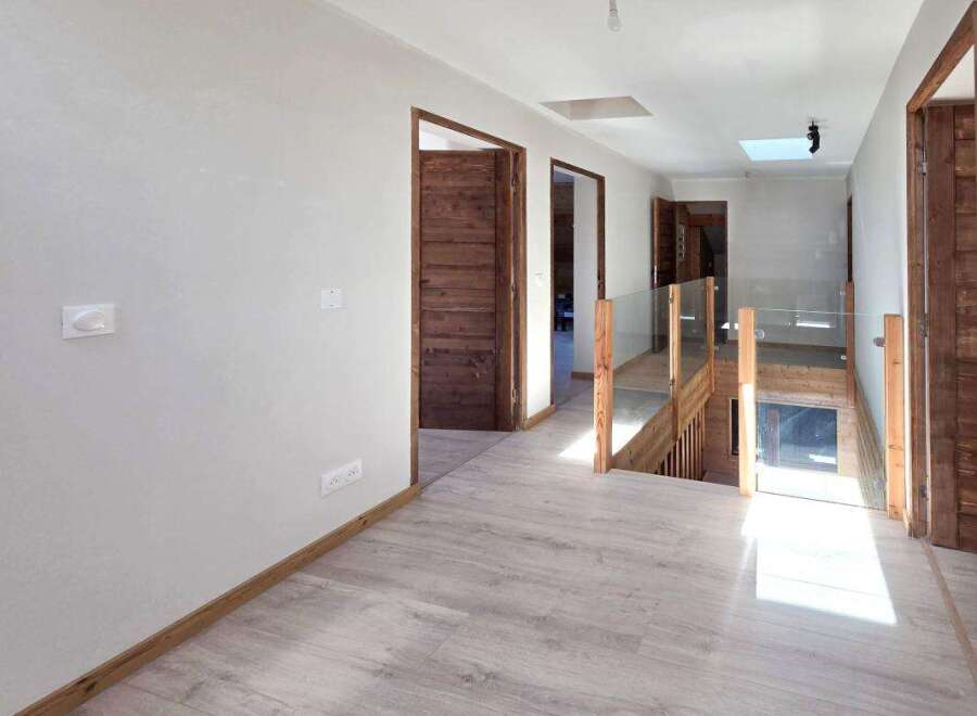Step into this beautifully designed hallway, featuring light wood-look flooring and a modern aesthetic.
