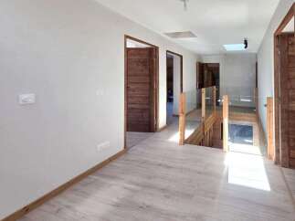 Step into this beautifully designed hallway, featuring light wood-look flooring and a modern aesthetic.