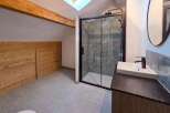 Experience modern comfort in this attic bathroom, featuring a sleek walk-in shower with stylish tiled walls and a contemporary vanity with a vessel sink.