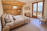 Experience the charm of this mountain retreat, featuring a cozy bedroom with a wooden sloped ceiling and a skylight for natural light.
