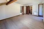 This spacious room features a modern, light wood-plank floor and crisp white walls, creating a bright and airy atmosphere.