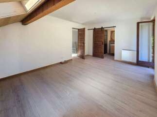 This spacious room features a modern, light wood-plank floor and crisp white walls, creating a bright and airy atmosphere.