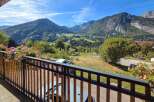 Enjoy breathtaking mountain views from this charming property's balcony, adorned with vibrant flowers.