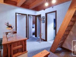 Discover this charming attic space featuring exposed wooden beams and a unique sloped ceiling, creating a cozy and rustic atmosphere.