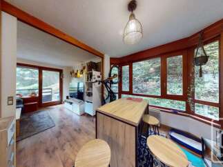 Experience cozy living in this charming apartment featuring a modern kitchen island with bar stools, perfect for casual dining.