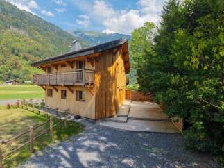 Experience rustic charm in this beautiful wooden chalet nestled against a stunning mountain backdrop.