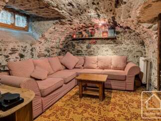Experience rustic charm in this cozy living space featuring a large sectional sofa with checkered upholstery, perfect for relaxing evenings.