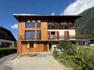 Experience alpine living in this charming wooden chalet, featuring expansive windows and multiple balconies offering stunning mountain views.