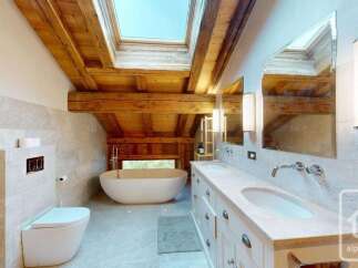 Experience luxury in this stunning bathroom featuring a freestanding soaking tub positioned perfectly under a skylight for natural illumination.