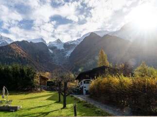 Experience the breathtaking beauty of the Alps from this stunning property, nestled amidst vibrant autumn foliage and majestic snow-capped peaks.