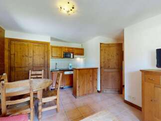 This charming apartment features a cozy dining area with a wooden table and chairs, perfect for family meals.