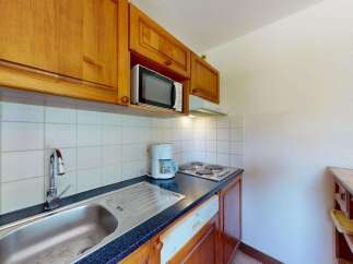 This charming kitchen features warm wooden cabinetry and a sleek granite countertop.
