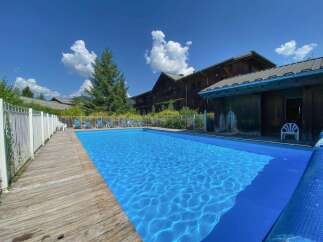 Enjoy a refreshing dip in this stunning outdoor swimming pool, perfect for a summer getaway.