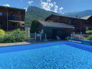Enjoy a refreshing dip in this stunning outdoor swimming pool, perfect for a summer getaway.