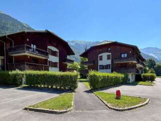 Experience alpine living in this charming wooden apartment complex, nestled against a backdrop of majestic mountains.