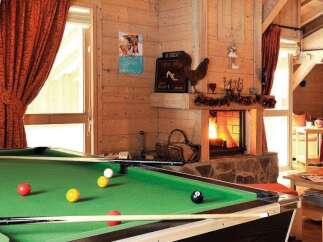 Experience ultimate relaxation in this charming mountain chalet, featuring a cozy living area with a roaring fireplace and a full-size pool table for evening entertainment.