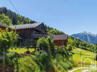 Nestled in a serene mountain landscape, this charming wooden chalet offers breathtaking views of snow-capped peaks and lush green valleys.