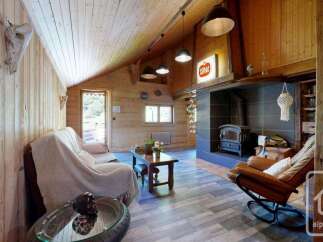 Experience rustic charm in this cozy living room, featuring a wood-burning stove and a comfortable sofa perfect for relaxing evenings.