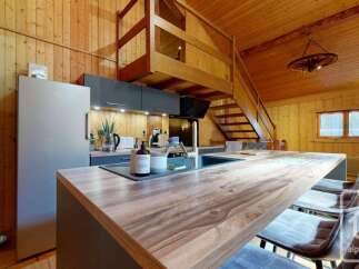 Experience the charm of this rustic kitchen, featuring warm wooden paneling throughout and a spacious island perfect for meal preparation and casual dining.