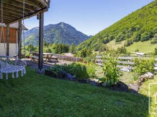 Enjoy breathtaking mountain views from this charming property's covered patio, complete with a comfortable swing chair.