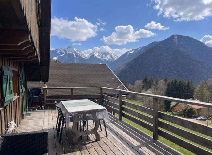 Enjoy breathtaking mountain views from this charming wooden cabin's spacious deck.