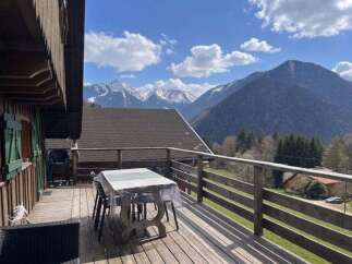 Enjoy breathtaking mountain views from this charming wooden cabin's spacious deck.
