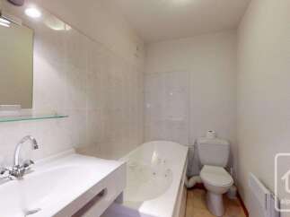 This charming bathroom features a spacious white bathtub, perfect for a relaxing soak.