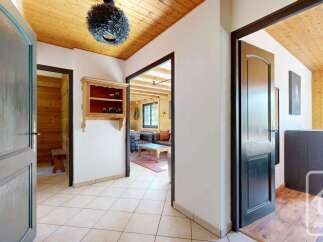 Step into this charming entryway featuring warm wooden ceilings and elegant dark wood doors.