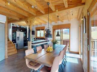 Experience rustic charm and modern comfort in this spacious dining area, featuring a large wooden table perfect for gatherings.