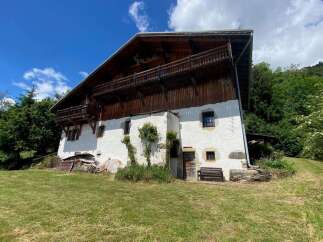 Charming traditional alpine chalet nestled amidst lush greenery, offering a serene mountain retreat.